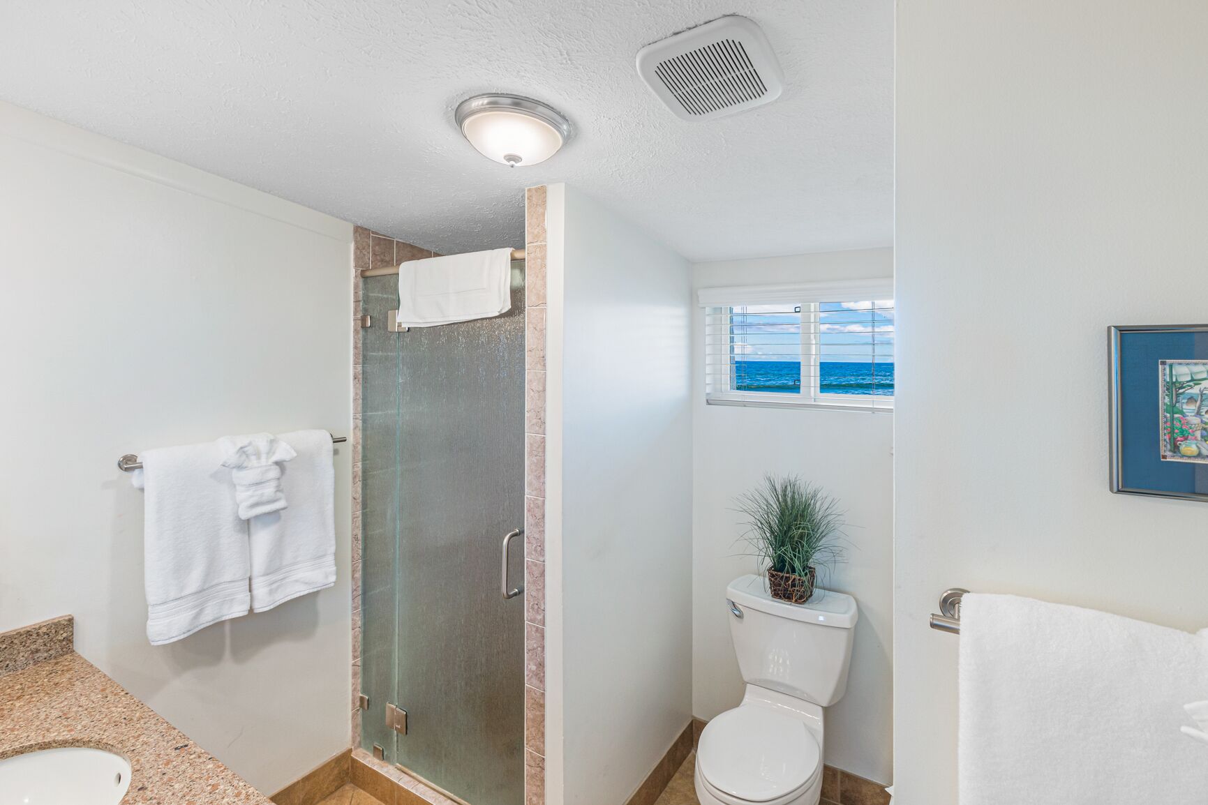 Un baño con ducha de vidrio, inodoro y lavamanos.