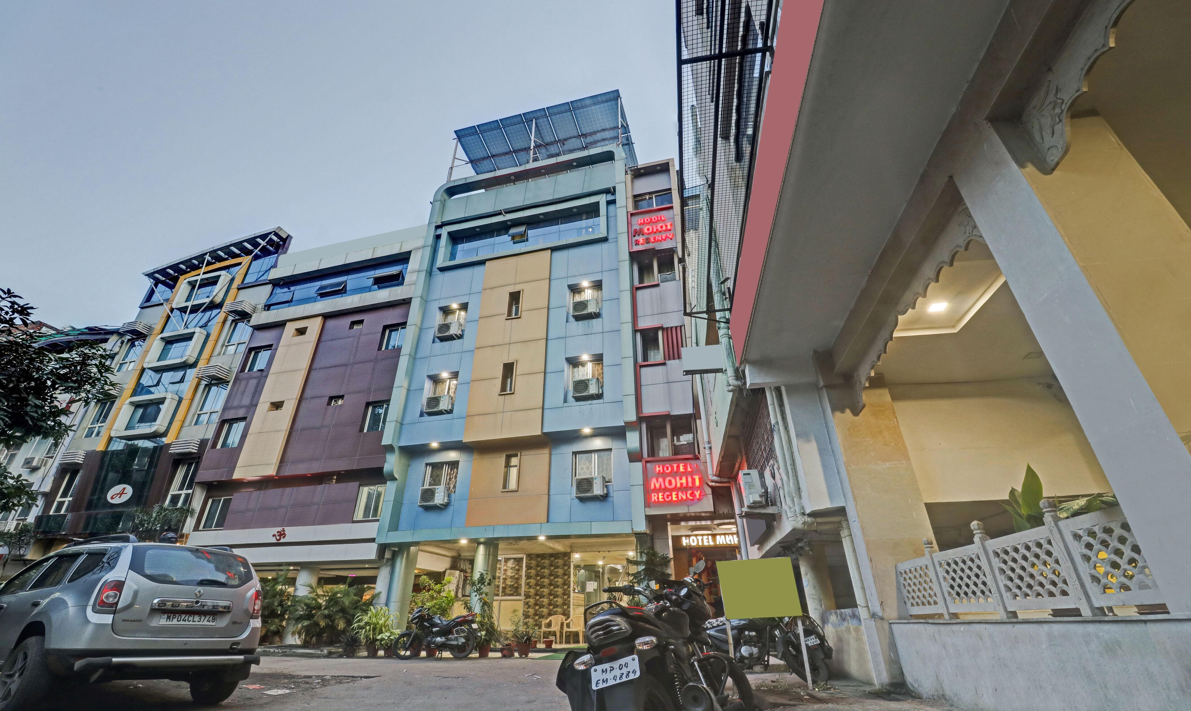 A multi-story hotel with a modern facade, multiple balconies, and a sign indicating it is a hotel.