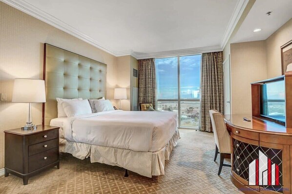 Une chambre d’hôtel avec un grand lit, un bureau et une télévision.