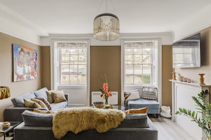Un salon avec un canapé, une table basse et une cheminée.