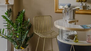 A dining area with a round table, a chair, a potted plant, and a mirror with a golden frame. - Impeccable 4-bed Apartment in Bath (Bath)