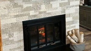 A fireplace with a stone wall, a clock, antlers mounted above, and a basket of logs. - Sugar In The Sky - Quiet End Unit w/ Air Conditioning & Work Space (Sugar Mountain)
