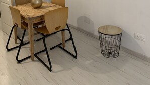A dining area with a wooden table, chairs, a vase, and a small round table with a wireframe base. - Maisonette with garden (Mornas)