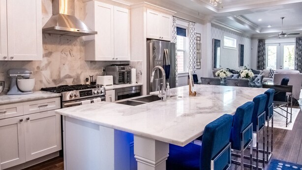 A modern kitchen with white cabinetry, stainless steel appliances, and a marble island. - Mid City Gorgeous Custom 4/3 one block from Street Car (New Orleans)