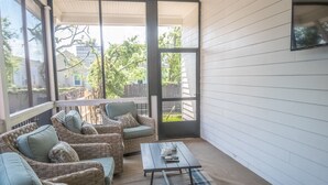 A covered porch with wicker furniture, a table, and a view of the backyard. - Mid City Gorgeous Custom 4/3 one block from Street Car (New Orleans)