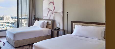 A hotel room with two beds, a city view, a large abstract painting, and a modern design.