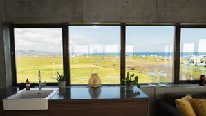 Une cuisine moderne dotée d’une grande fenêtre, d’un évier et d’un meuble en bois foncé.