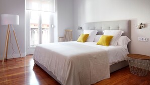 Ein Schlafzimmer mit einem großen Bett, einer Stehlampe und Blick auf den Balkon.