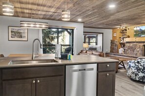 Una cocina moderna con una isla grande, electrodomésticos de acero inoxidable y una chimenea de piedra.