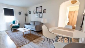 Uma sala de estar moderna com sofá, mesa de centro e área de refeições.