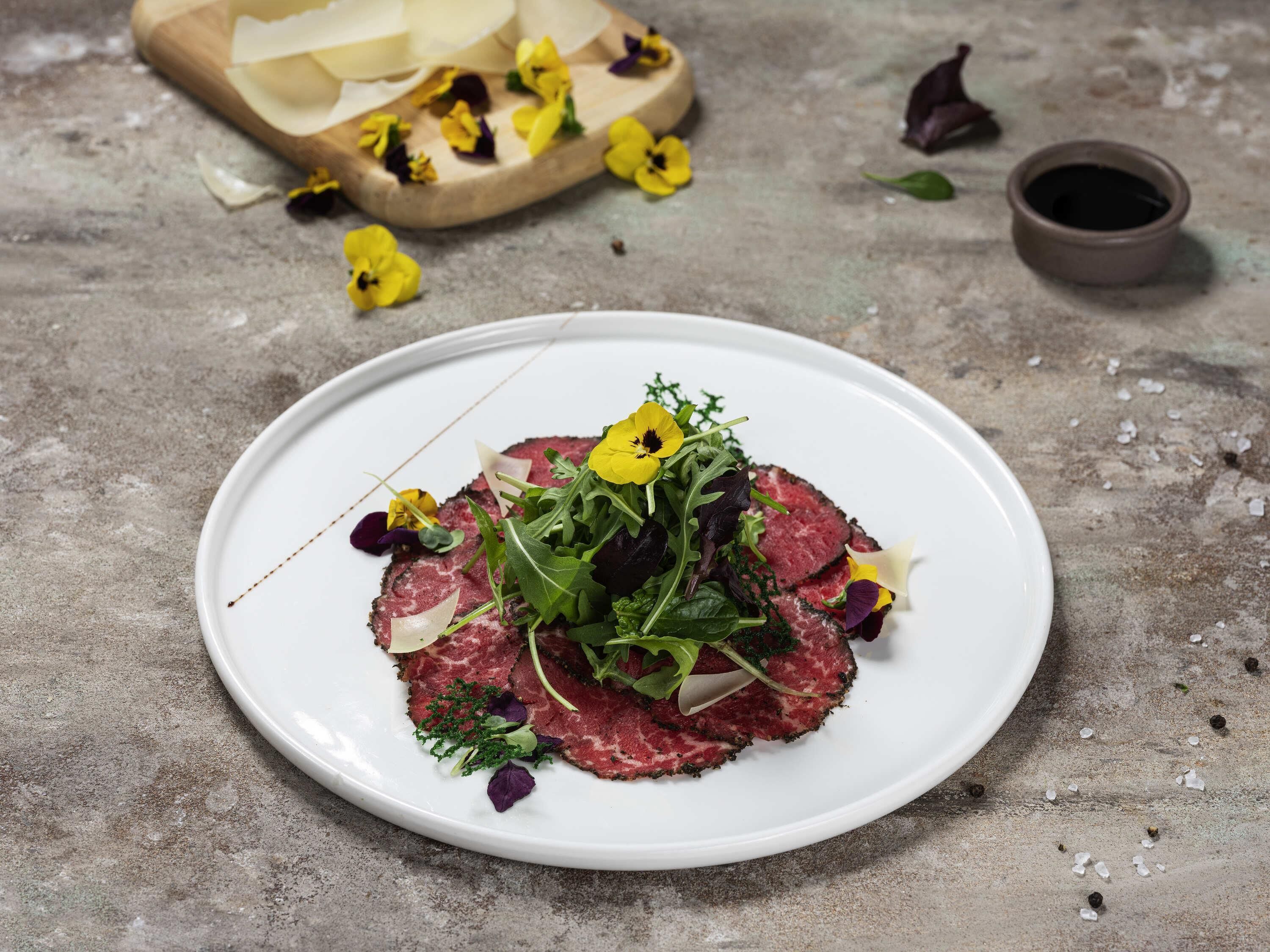 A plate of food with various greens and flowers.