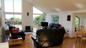 A spacious living room with a fireplace, a large window, and a balcony. - Annapurna -  a house that sleeps 8 guests  in 4 bedrooms (Portpatrick, Stranraer)