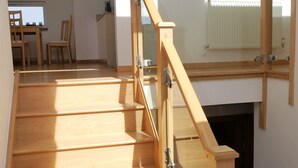 A wooden staircase with glass railings leading to an upper floor. - Annapurna -  a house that sleeps 8 guests  in 4 bedrooms (Portpatrick, Stranraer)