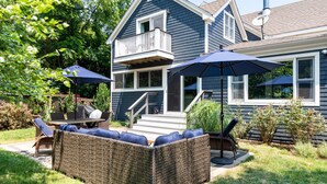 A house with a balcony, outdoor furniture, and a covered patio area. - Enjoy Newport, stunning beaches, hot-tub, & relax at the lovely Coastal Hideaway (Middletown)