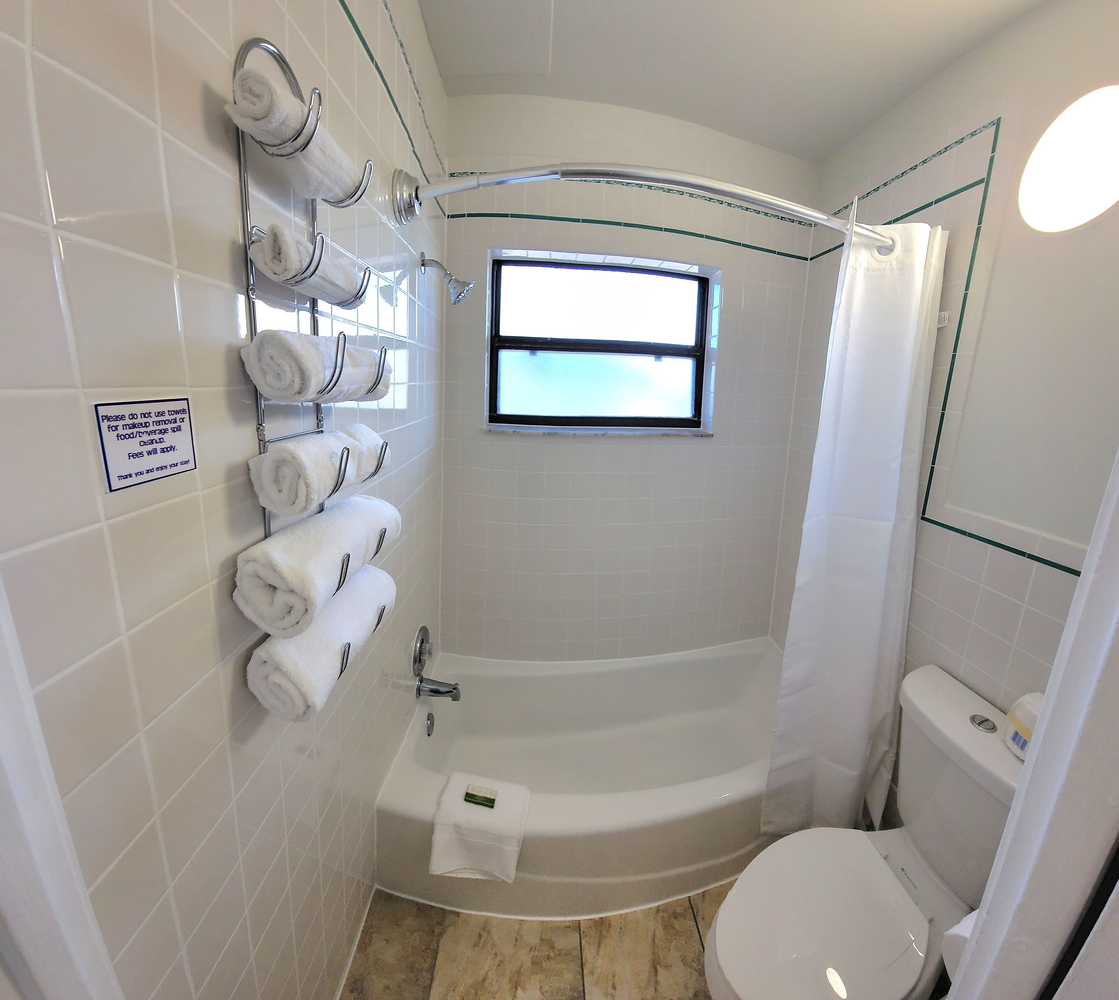 Ein Badezimmer mit Badewanne, Toilette und einem Handtuchhalter mit mehreren Handtüchern.