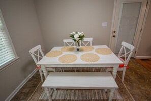 A white dining table with six placemats, a vase with flowers, and four chairs. - The "Hartwell" House (Hartwell)