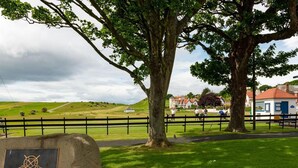 A stone plaque with the text "GULLANE GOLF CLUB 1882" on a grassy area with a fence and trees. - Rosebery Place in the Heart of Gullane (Gullane)