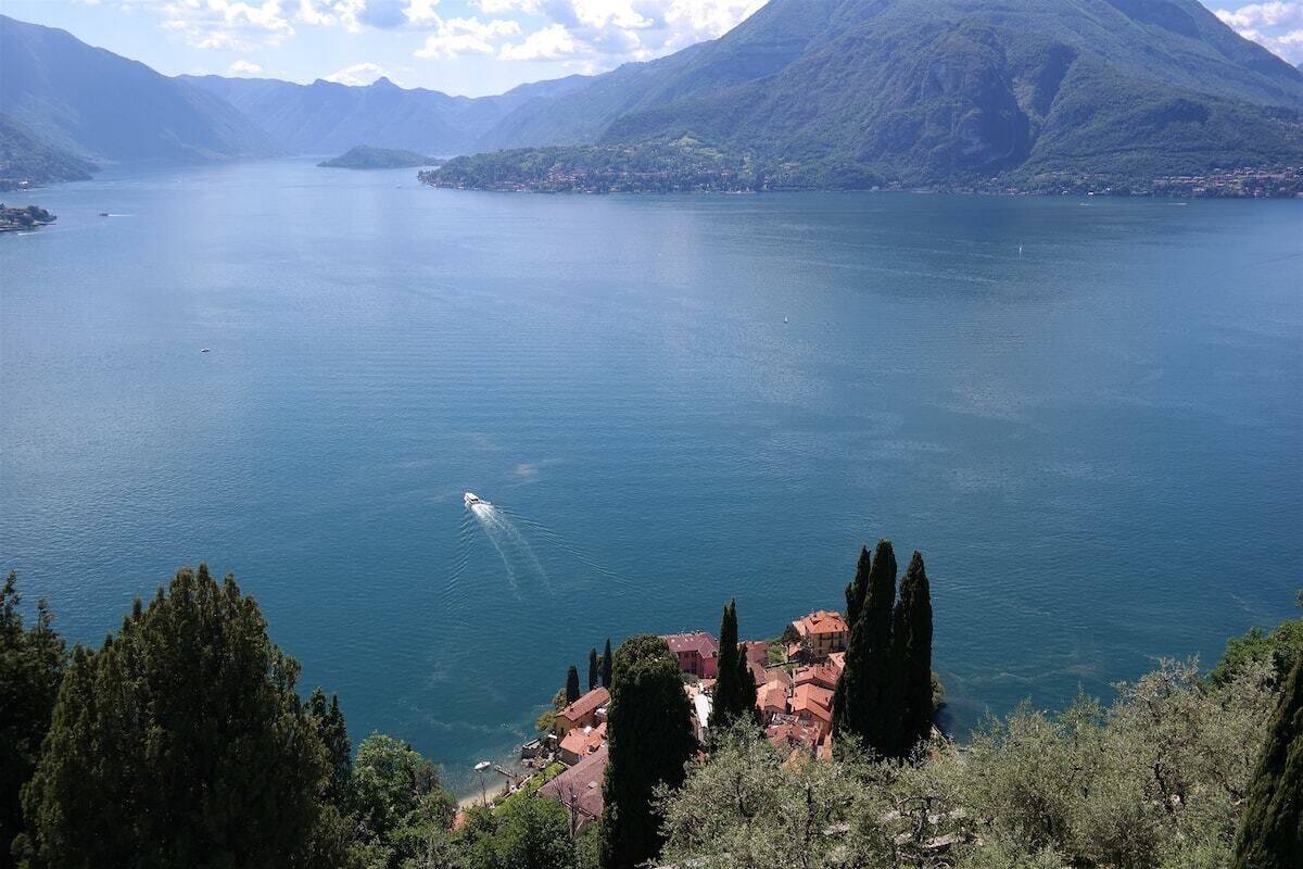 A lake with a small town and mountains in the background.