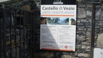 Een bordje voor het Castello di Vezio met openingstijden en een regels voor bezoekers.