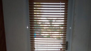 A door with horizontal blinds, a doormat, and a tiled floor. - Island hide away 1 (Freeport)