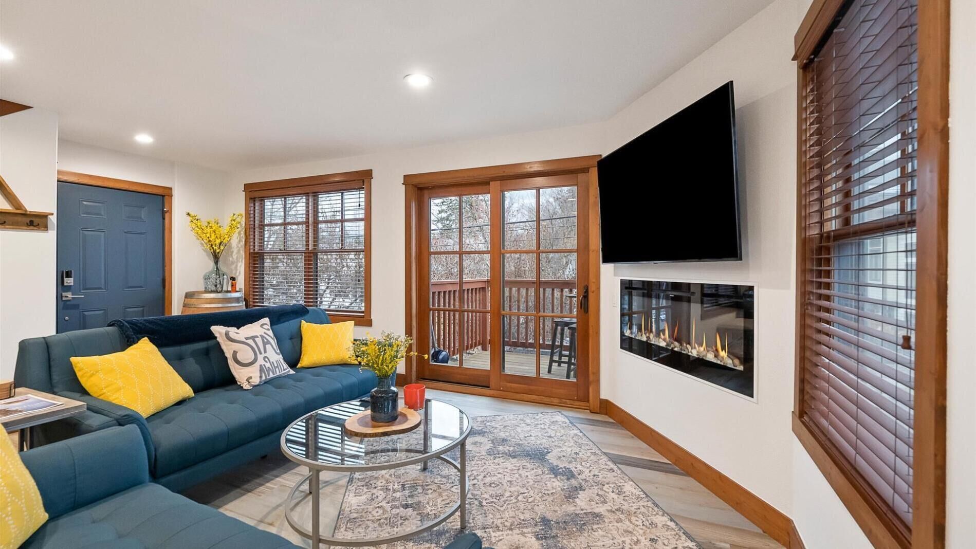 A living room with a blue sofa, a coffee table, and a fireplace.