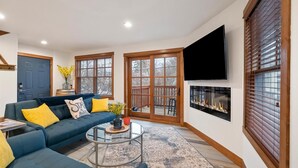 A living room with a blue sofa, a coffee table, and a fireplace.