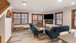 A living room with a sofa, a coffee table, a TV, and a fireplace.