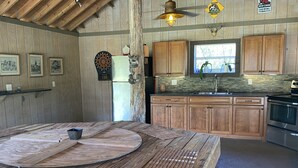 Een landelijke keuken met houten kastjes, een centraal eiland en een betegelde achterwand.