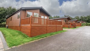 Une rangée de chalets en bois, avec une allée pavée et des pelouses verdoyantes.