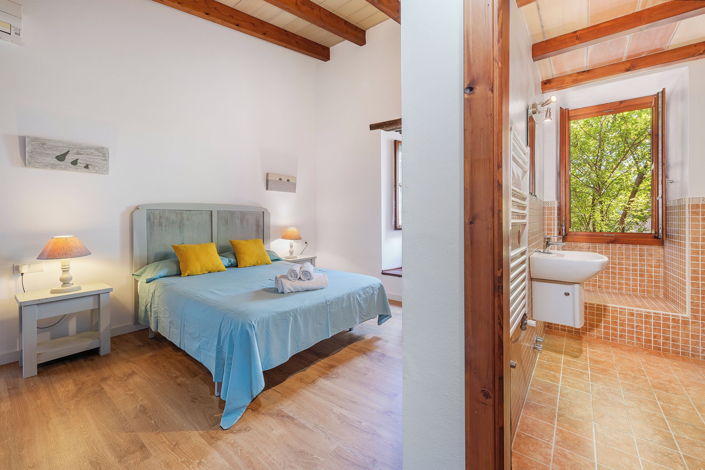 A bedroom with a bed, nightstands, and a view of the bathroom.