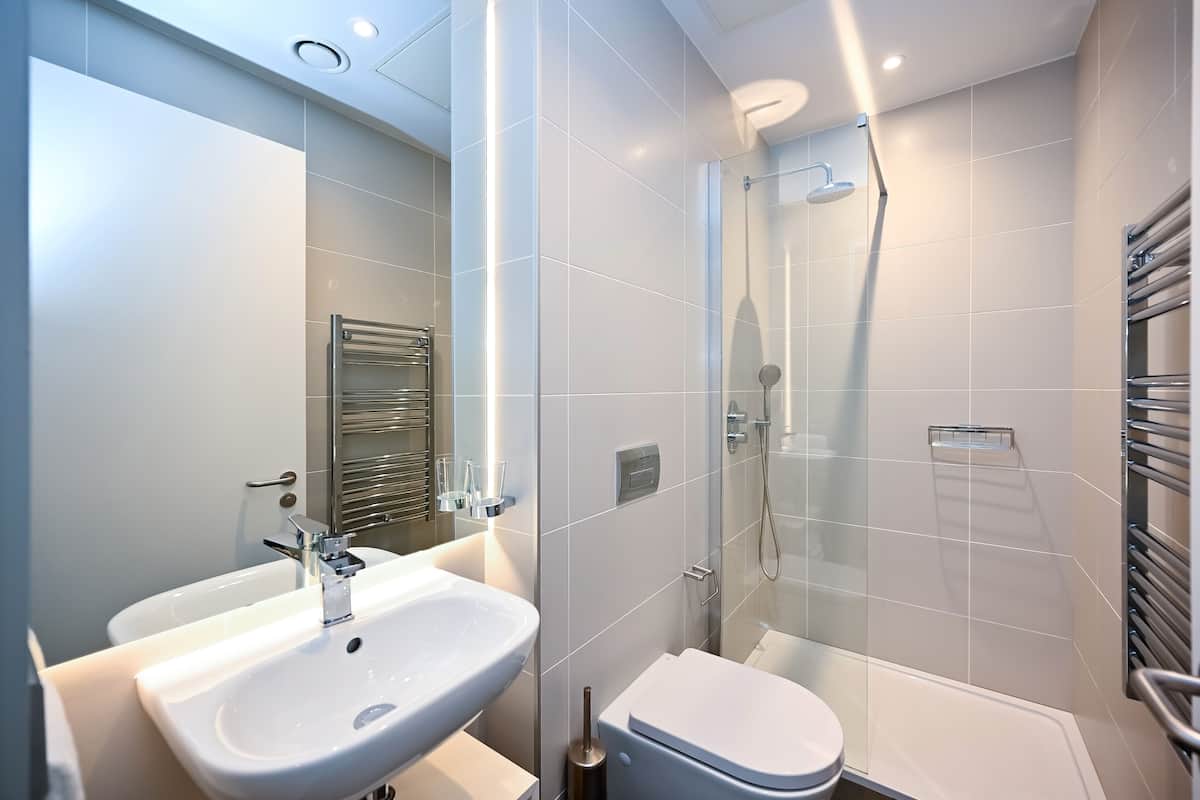 Ein modernes Badezimmer mit Waschbecken, Toilette und einer Duschkabine.