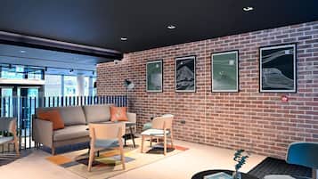A modern interior with a brick wall, a sofa, chairs, and artwork.