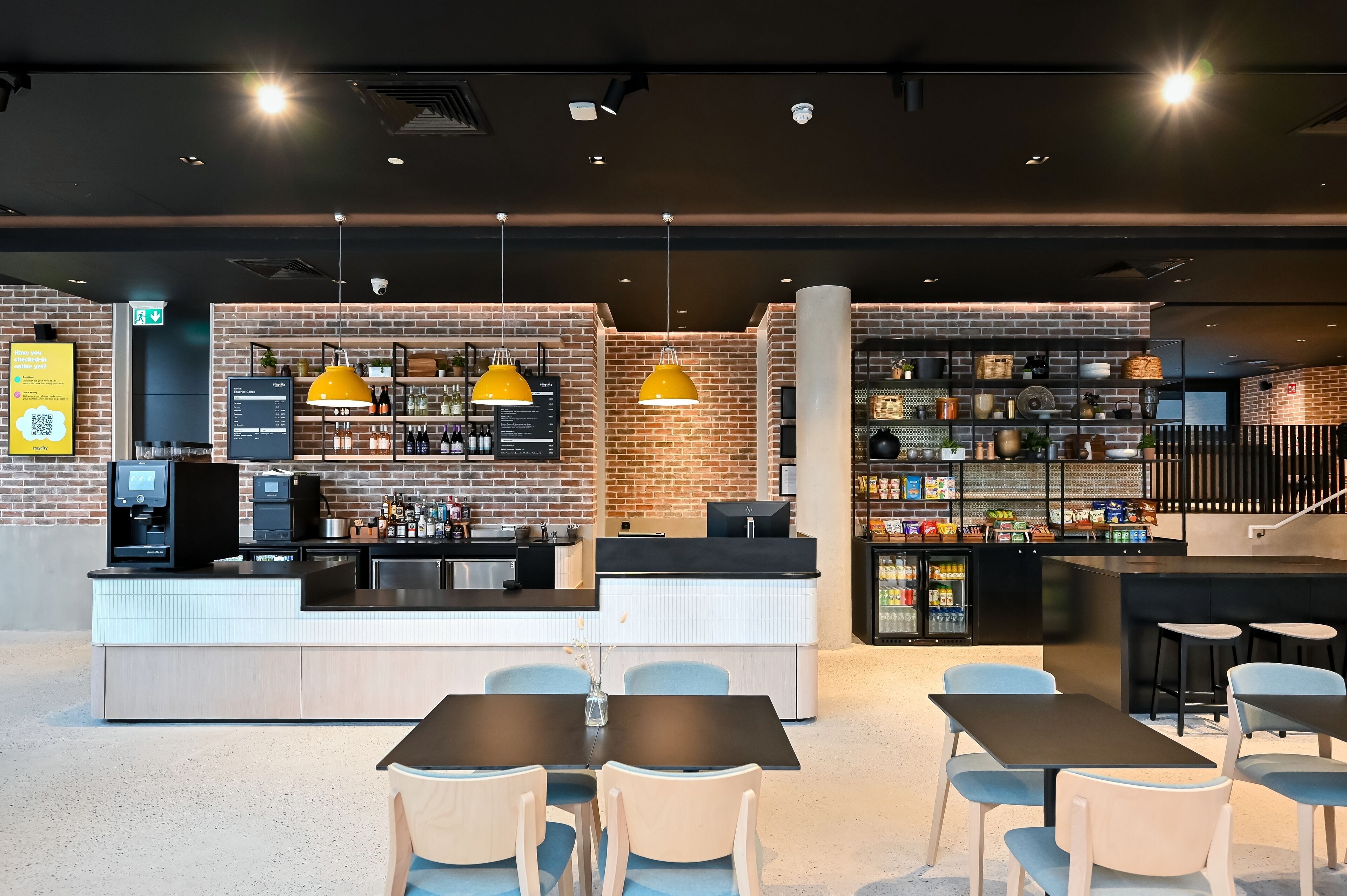 Un café moderne avec un mur en briques, un comptoir et un espace salon.