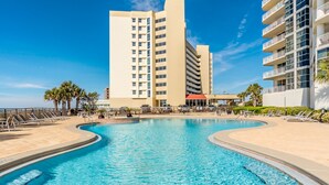 A pool area with lounge chairs, a clear blue pool, and a tall building in the background. - Palacio 3/2 on 17th Floor with a Million Dollar View (Pensacola)