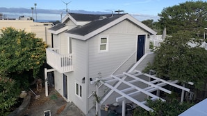 Una casa a due piani con un balcone, un garage e un piccolo giardino.