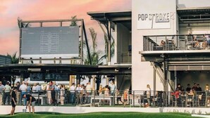 A modern building with a sign reading "POPSTROKE" and a crowd of people outside. - WaterFront View 2 BDR 1.5 BA Home (Katy)