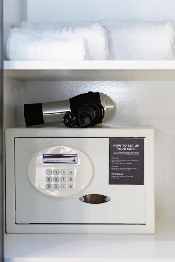A keypad entry system with a manual override key, a safety instruction label, and a towel storage area above.