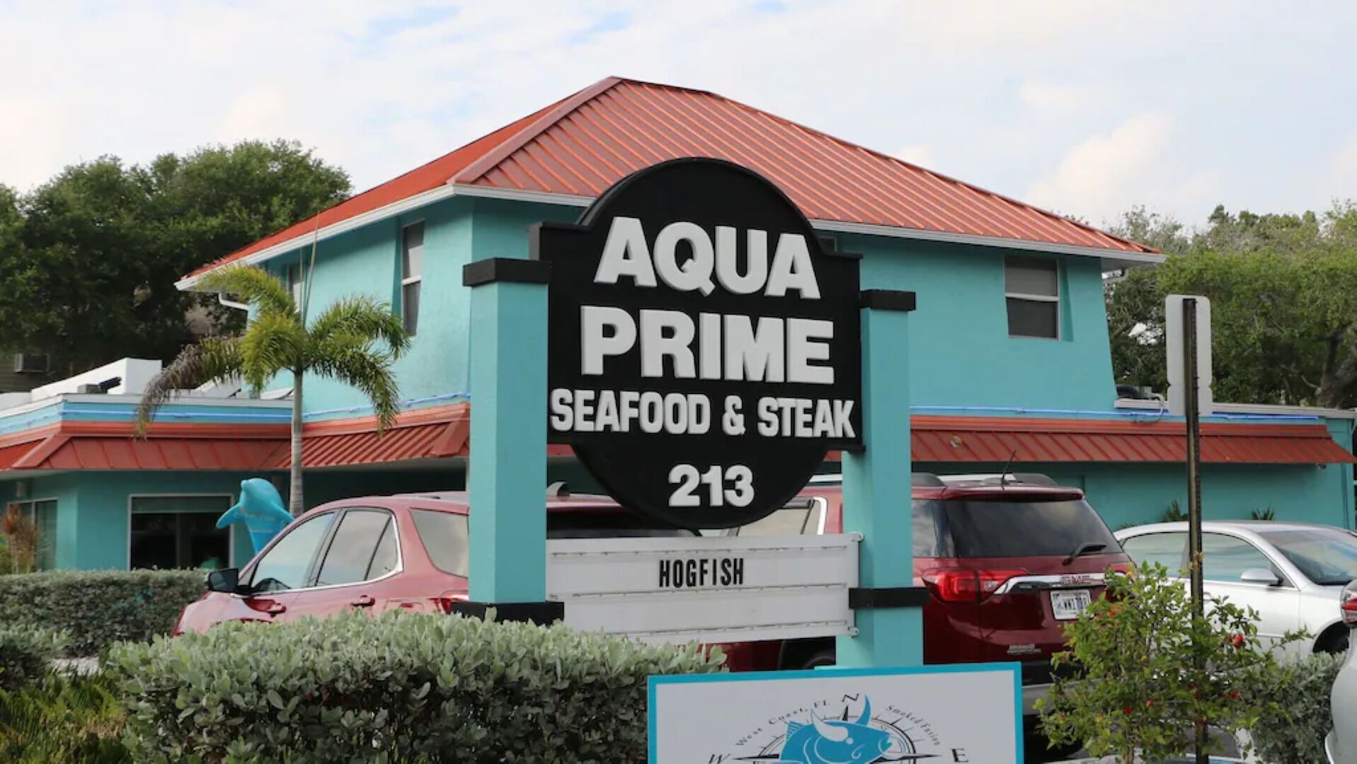 A sign for 'AQUA PRIME Seafood & Steak' with the number 213.