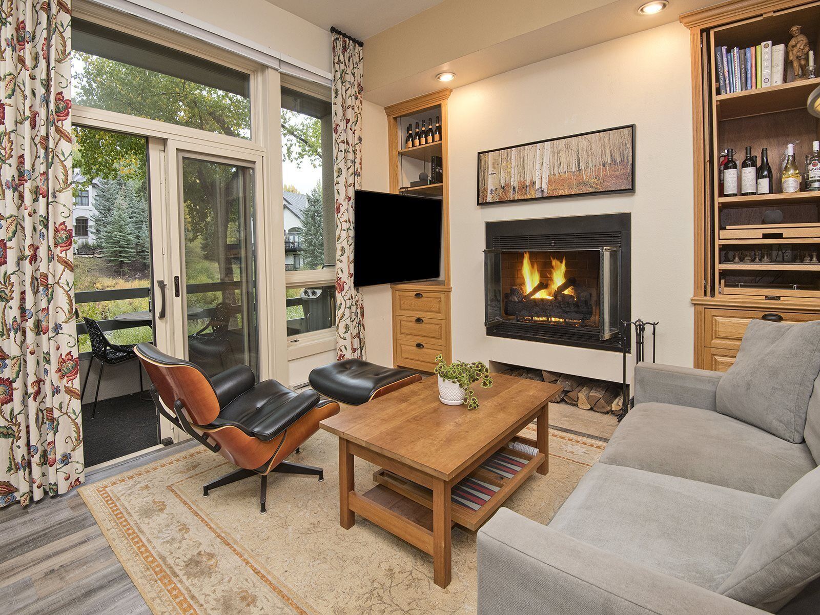 A living room with a fireplace, a television, and a bookshelf.