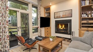 Ein Wohnzimmer mit Kamin, Fernseher und Bücherregal.