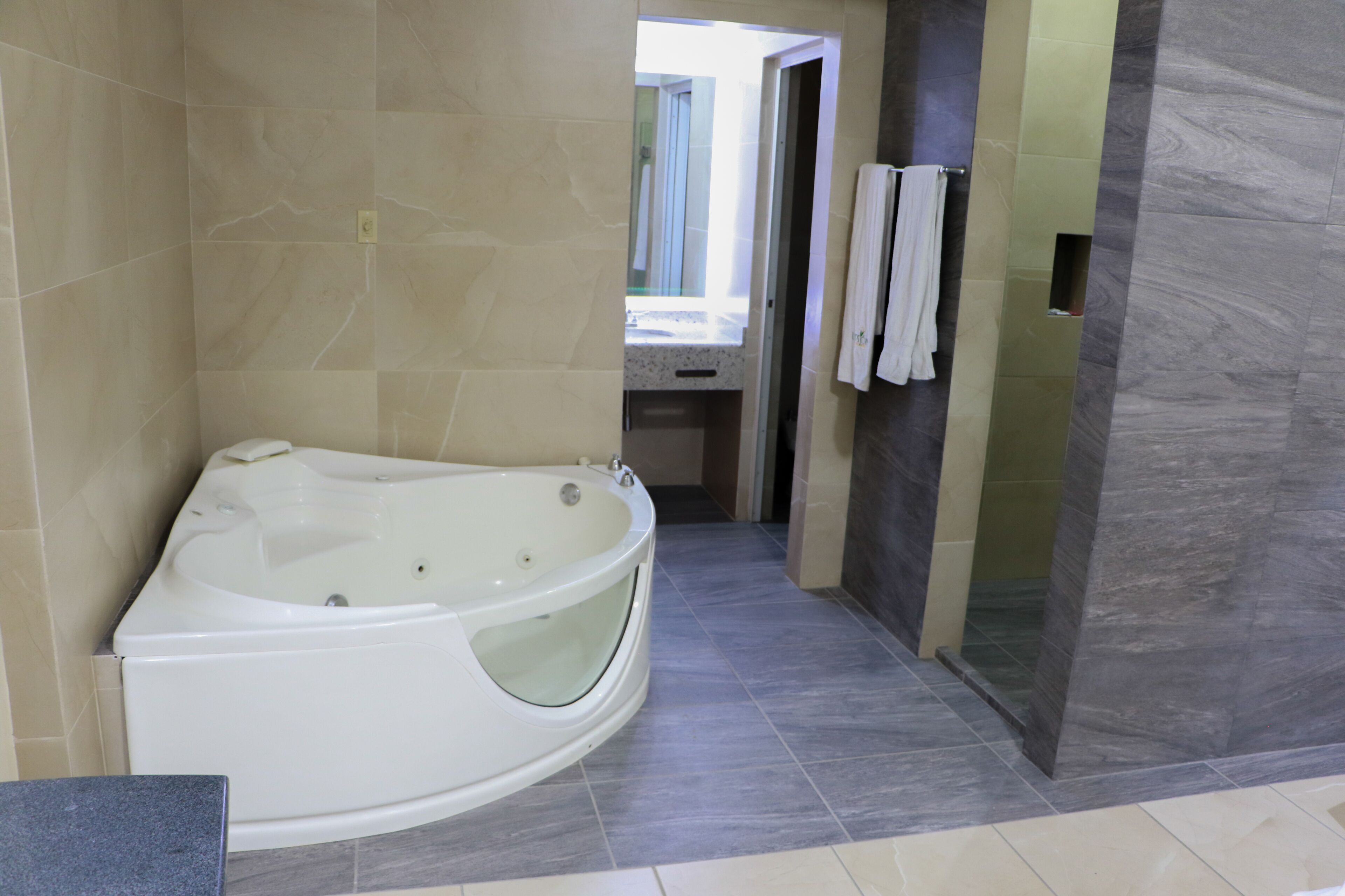 A modern bathroom with a freestanding bathtub, a vanity with a mirror, and a towel rack.