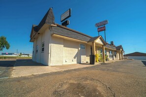 A small, single-story building with a sloped roof, a sign for Wendy's, and a sign indicating a lobby.
