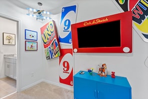Una habitación con un armario azul, un televisor y adornos de pared, incluyendo un cartel grande con el número 9.