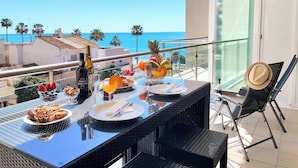 A dining table set with food and drinks on a balcony with a view of the sea. - Beach Condo with Atlantic Ocean view by Be Cherish (Albufeira)