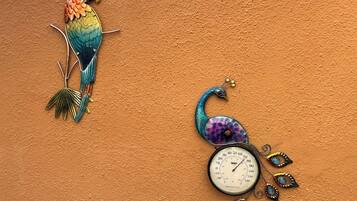 Una pared con un colorido pavo real y un reloj.