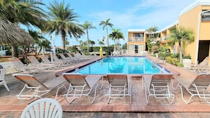 A swimming pool with sun loungers and palm trees. - Satellite Motel - Shore Thing 111 (Treasure Island)