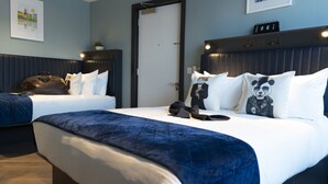 A hotel room with two beds, a dark headboard, a clock, and a framed picture on the wall. - Dublin One Hotel (Dublin)
