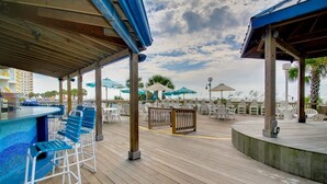 Une terrasse en bois avec un espace salon extérieur et une piscine.