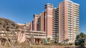 Un immeuble résidentiel à plusieurs étages doté d’une cour intérieure, de balcons et d’un garage.