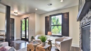 Un salon moderne avec un canapé, des fauteuils, une table basse et une cheminée.